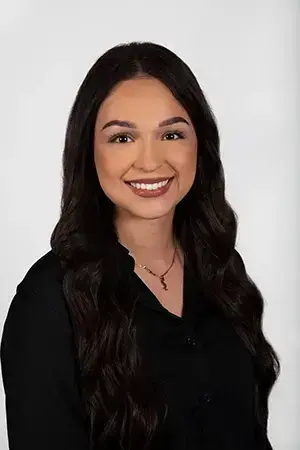 Ashley, dental team member at Las Vegas practice, smiling in professional portrait.