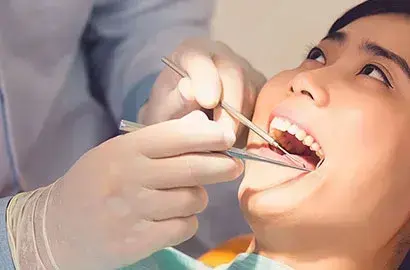 Dentist applying dental crown to patient's tooth during treatment in Las Vegas.