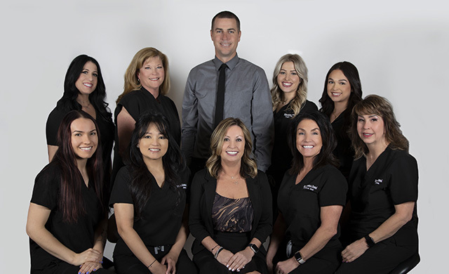 Professional dental team portrait of eight staff members in Las Vegas dental practice.