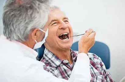 Dentist examining patient's teeth during dental implant consultation in Las Vegas.