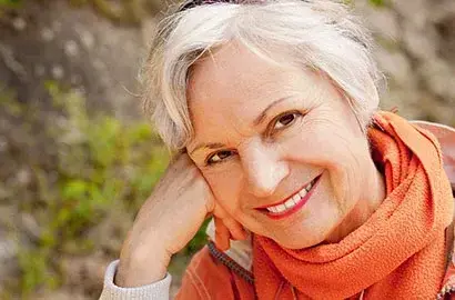 Smiling older woman with white hair wearing an orange scarf in Las Vegas.