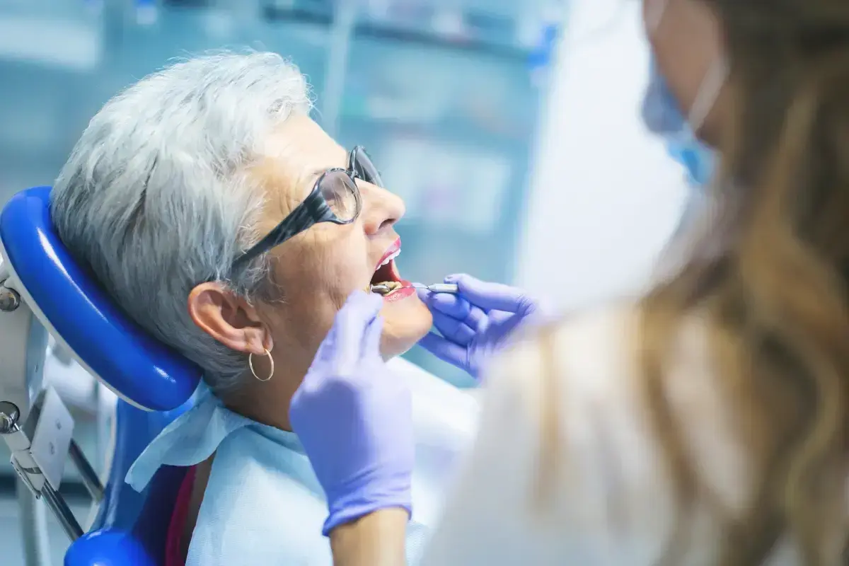 Senior patient receiving dental examination from dentist in Las Vegas office.