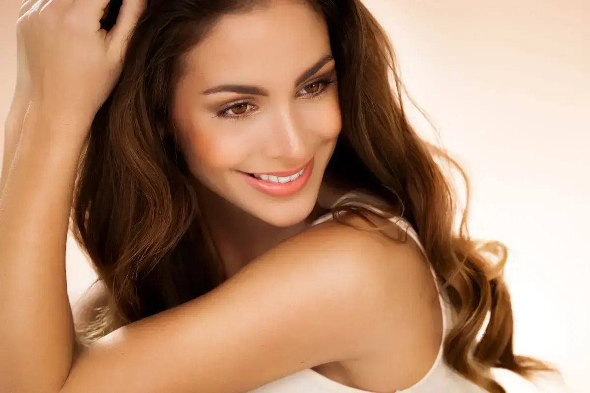 Woman with bright, white smile demonstrating professional teeth whitening results.